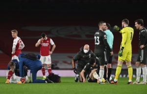 LONDON, ENGLAND - JANUARY 30: Alexandre Lacazette of Arsenal and Harry Maguire of Manchester United receive treatment after a challenge during the Premier League match between Arsenal and Manchester United at Emirates Stadium on January 30, 2021 in London, England. Sporting stadiums around the UK remain under strict restrictions due to the Coronavirus Pandemic as Government social distancing laws prohibit fans inside venues resulting in games being played behind closed doors. (Photo by Andy Rain - Pool/Getty Images)