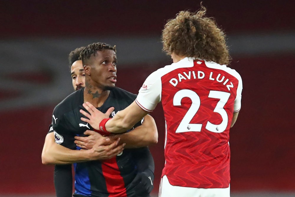 Crystal Palace's Ivorian striker Wilfried Zaha (L) clashes with Arsenal's Brazilian defender David Luiz (R) during the English Premier League footb...