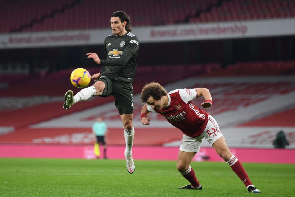 Arsenal's Brazilian defender David Luiz (R) heads the ball away from Manchester United's Uruguayan striker Edinson Cavani (L) during the English Premier League football match between Arsenal and Manchester United at the Emirates Stadium in London on January 30, 2021. (Photo by Shaun Botterill / POOL / AFP)