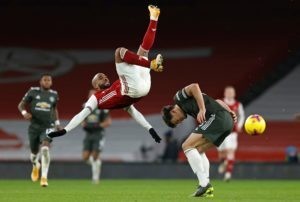 Arsenal's French striker Alexandre Lacazette (L) clashes with Manchester United's English defender Harry Maguire during the English Premier League football match between Arsenal and Manchester United at the Emirates Stadium in London on January 30, 2021. (Photo by Ian KINGTON / IKIMAGES / AFP)