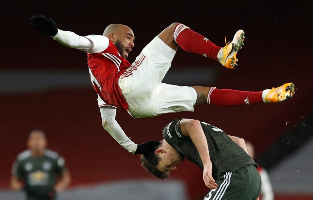 Arsenal's French striker Alexandre Lacazette (top) clashes with Manchester United's English defender Harry Maguire during the English Premier Leagu...