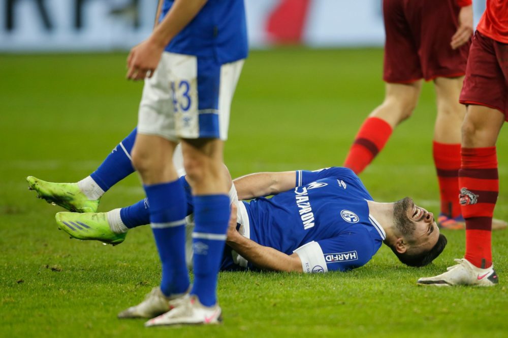 Schalke's German defender Sead Kolasinac lies injured on the ground during the German first division Bundesliga football match Schalke 04 v 1 FC Co...