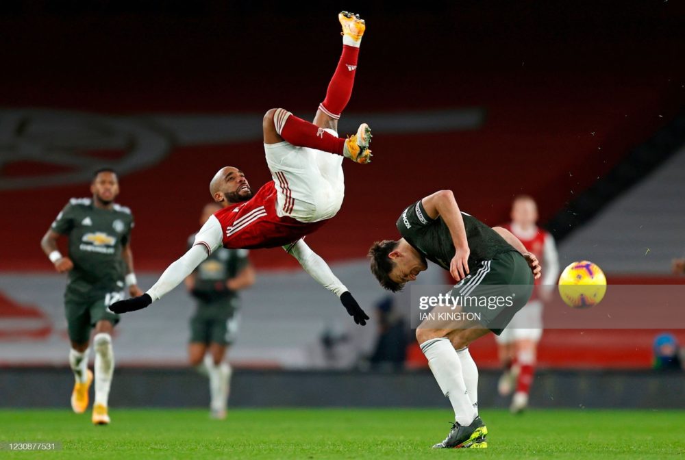 Arsenal's French striker Alexandre Lacazette (L) clashes with Manchester United's English defender Harry Maguire during the English Premier League football match between Arsenal and Manchester United at the Emirates Stadium in London on January 30, 2021. (Photo by Ian KINGTON / IKIMAGES / AFP)
