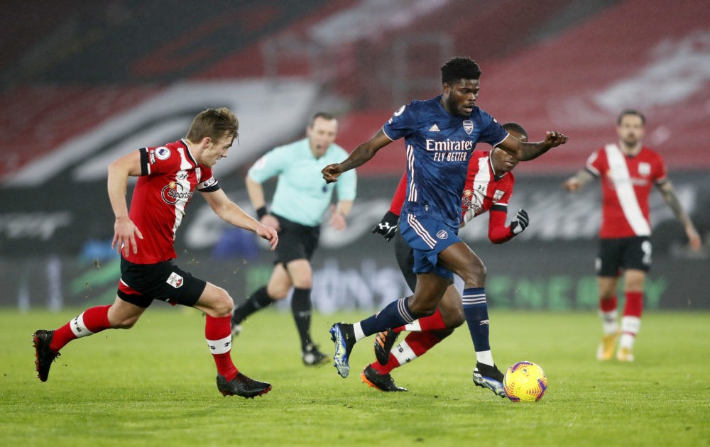 SOUTHAMPTON, ENGLAND: Thomas Partey of Arsenal runs with the ball away from James Ward-Prowse (L) and Ibrahima Diallo (obscure/R) of Southampton du...