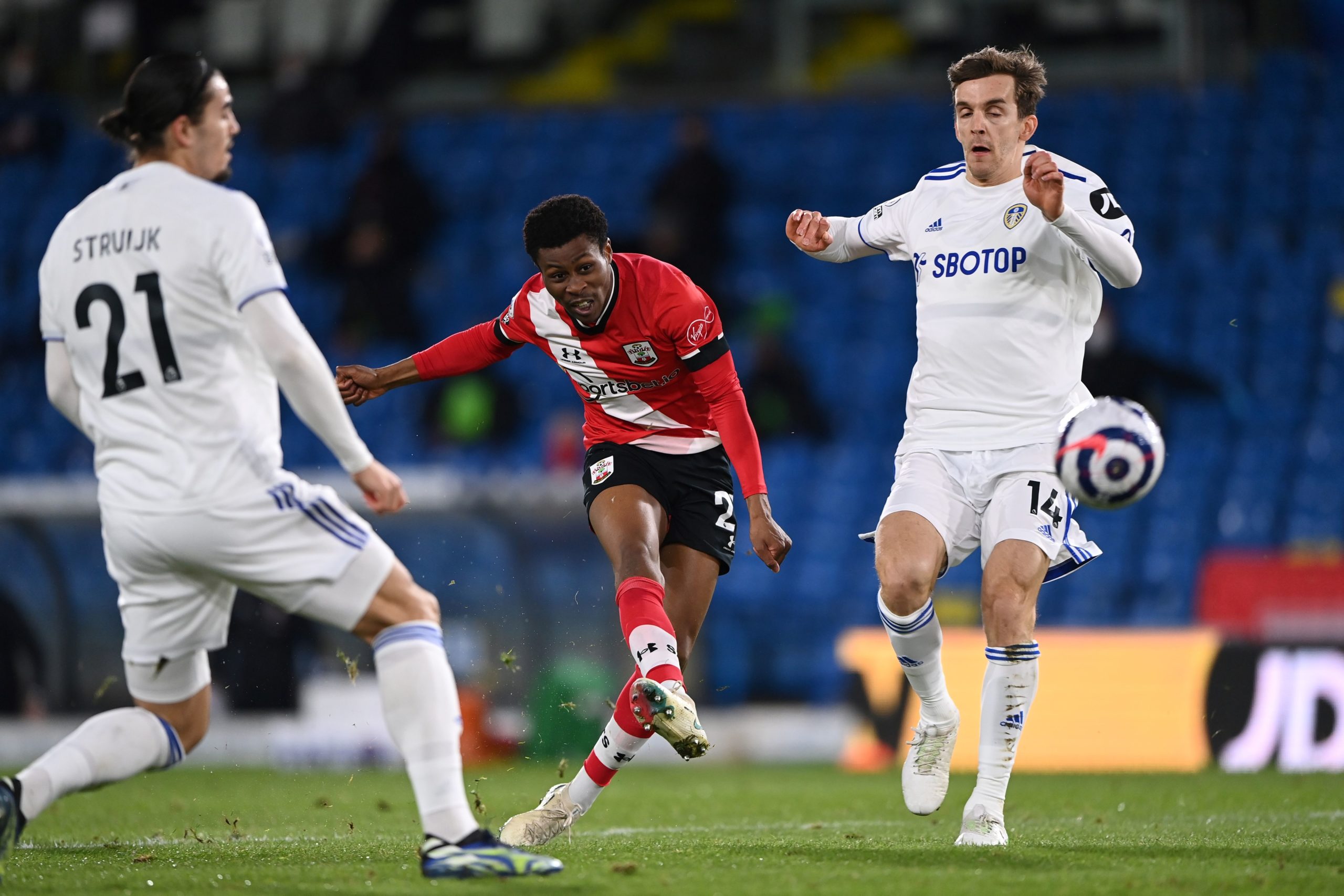 Southampton's English midfielder Nathan Tella (C) takes a shot past Leeds United's Spanish defender Diego Llorente (R) during the English Premier L...