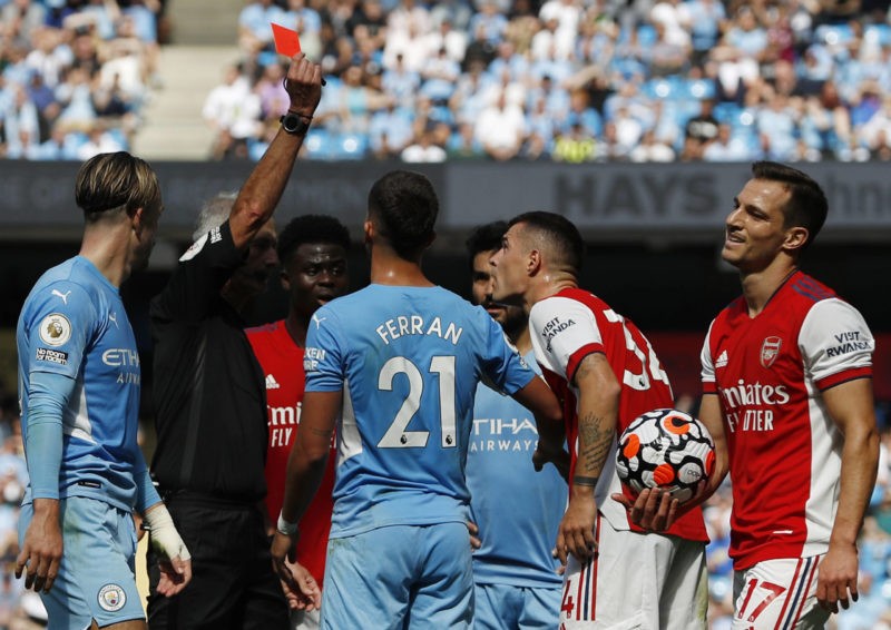 Manchester, England, 28th August 2021. Granit Xhaka of Arsenal is shown a red card by referee Martin Atkinson during the Premier League match at th...