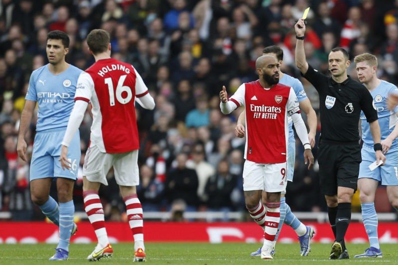 Arsenal's English defender Rob Holding (L) is shown a yellow card during the English Premier League football match between Arsenal and Manchester C...