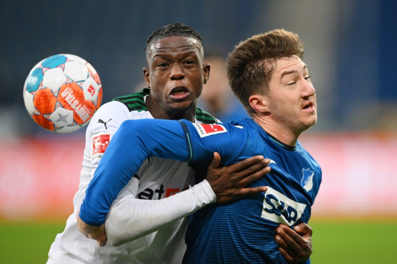 SINSHEIM, GERMANY - DECEMBER 18: Denis Zakaria of Borussia Moenchengladbach and Angelo Stiller of TSG 1899 Hoffenheim compete for a header during t...
