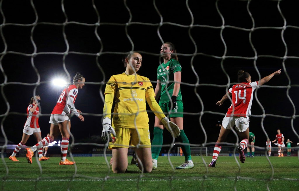 BOREHAMWOOD, ENGLAND: Lucy Thomas of Coventry United sits dejected as Nikita Parris of Arsenal runs off to celebrate after scoring the third goal during the Vitality Women's FA Cup Quarter Final match between Arsenal Women and Coventry United Ladies at Meadow Park on March 18, 2022. (Photo by Catherine Ivill/Getty Images)