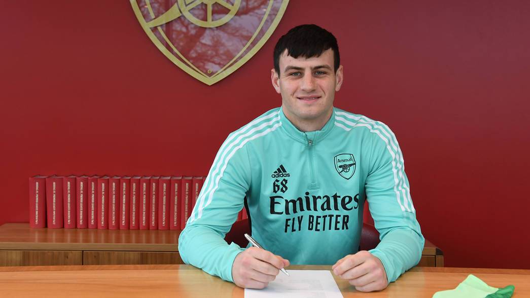 Tom Smith signing his contract extension with Arsenal (Photo via Arsenal.com)