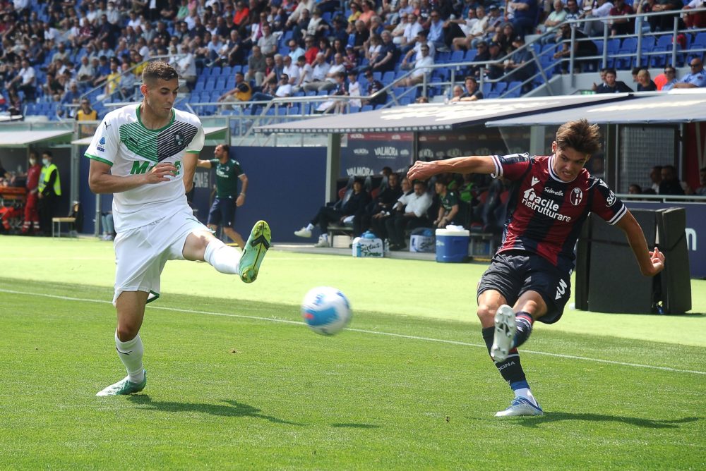 BOLOGNA, ITALY: Aaron Hickey of Bologna FC (R) kicks the ball past Mert Muldur of US Sassuolo (L) during the Serie A match between Bologna FC and U...