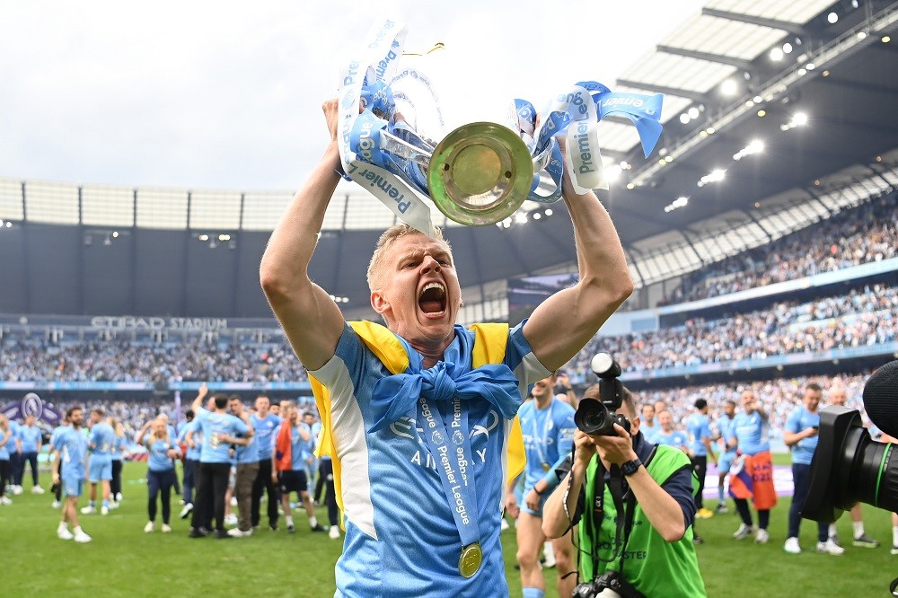 MANCHESTER, ENGLAND: Oleksandr Zinchenko of Manchester City celebrates with the Premier League trophy and a Ukrainian flag after their side finishe...