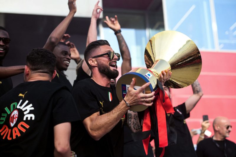 Olivier Giroud of AC Milan holds the Scudetto Trophy next to other AC Milan players parading on a double decker bus in Milan, on May 23, 2022 one day after AC Milan won the 2022 Italian Serie A "Scudetto" championship. - AC Milan won the Italian Serie A football match between Sassuolo and AC Milan, securing the "Scudetto" championship. (Photo by Piero CRUCIATTI / AFP) (Photo by PIERO CRUCIATTI/AFP via Getty Images)
