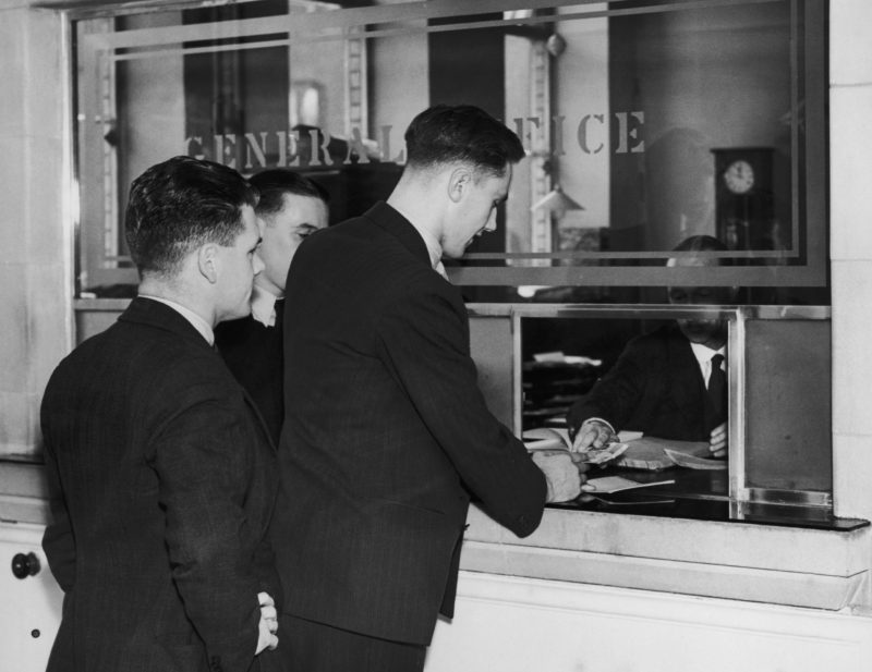 Arsenal footballers paying money into the bank at Highbury Stadium, North London as part of the club's saving scheme for players, 1st October 1938. (Photo by William G. Vanderson/Fox Photos/Getty Images)