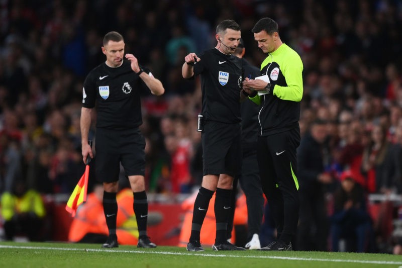 LONDON, ENGLAND - OCTOBER 09: Referee Michael Oliver speaks to fourth official Andy Madley during the Premier League match between Arsenal FC and L...