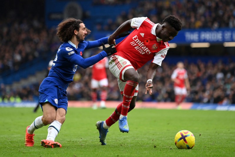 LONDON, ENGLAND - NOVEMBER 06: Bukayo Saka of Arsenal holds off Marc Cucurella of Chelsea during the Premier League match between Chelsea FC and Ar...