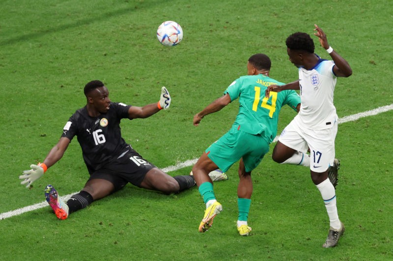 Bukayo Saka buzzing after England 3-0 win 2 AL KHOR, QATAR - DECEMBER 04: Bukayo Saka of England scores the team's third goal past Ismail Jakobs and Edouard Mendy of Senegal during the FIFA World Cup Qatar 2022 Round of 16 match between England and Senegal at Al Bayt Stadium on December 04, 2022 in Al Khor, Qatar. (Photo by Alexander Hassenstein/Getty Images)