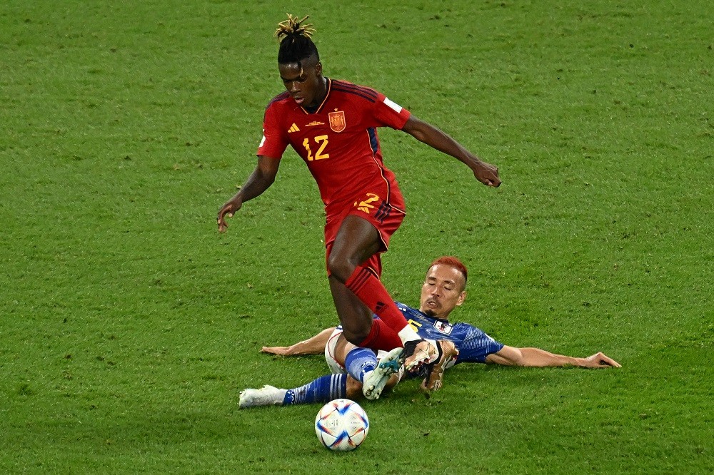 Spain forward Nico Williams is tackled by Japan defender Yuto Nagatomo during the Qatar 2022 World Cup Group E football match between Japan and Spa...