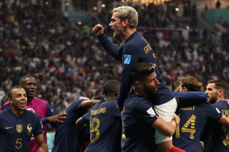 France's forward Antoine Griezmann (top) celebrates after forward #09 Olivier Giroud scored his team's second goal during the Qatar 2022 World Cup quarter-final football match between England and France at the Al-Bayt Stadium in Al Khor, north of Doha, on December 10, 2022. (Photo by ADRIAN DENNIS/AFP via Getty Images)
