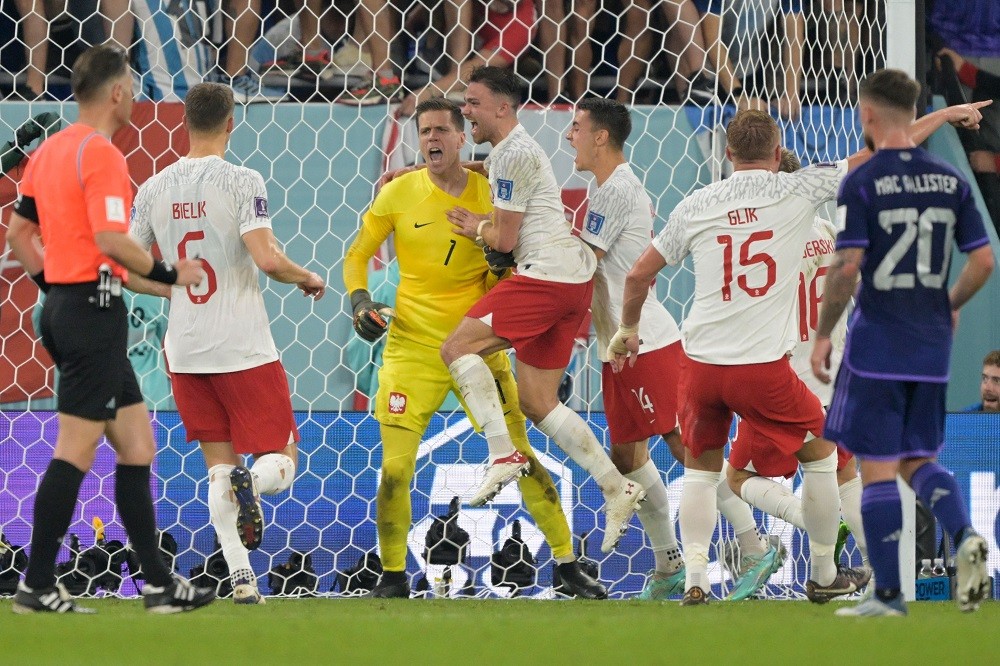 Poland's goalkeeper Wojciech Szczesny (C) celebrates with his teammates after he saved a penalty shot during the Qatar 2022 World Cup Group C footb...