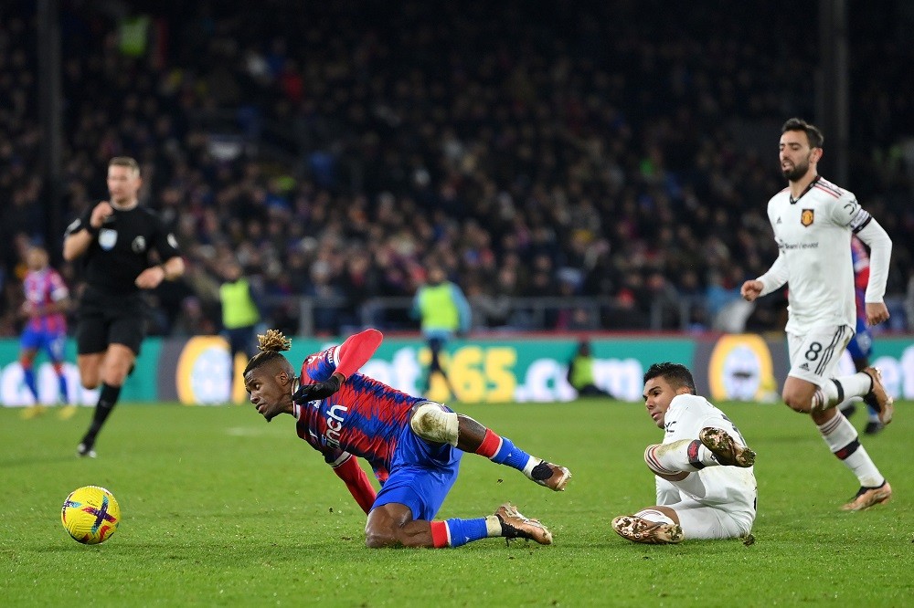 LONDON, ENGLAND: Casemiro of Manchester United fouls Wilfried Zaha of Crystal Palace leading to a yellow card during the Premier League match betwe...