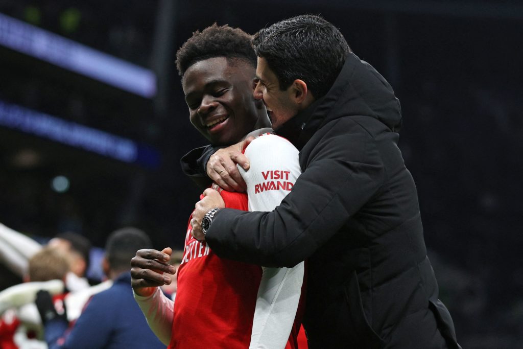 Arsenal's Spanish manager Mikel Arteta (R) celebrates with Arsenal's English midfielder Bukayo Saka on the pitch after the English Premier League football match between Tottenham Hotspur and Arsenal at Tottenham Hotspur Stadium in London, on January 15, 2023. - Arsenal won the game 2-0. (Photo by ADRIAN DENNIS/AFP via Getty Images)