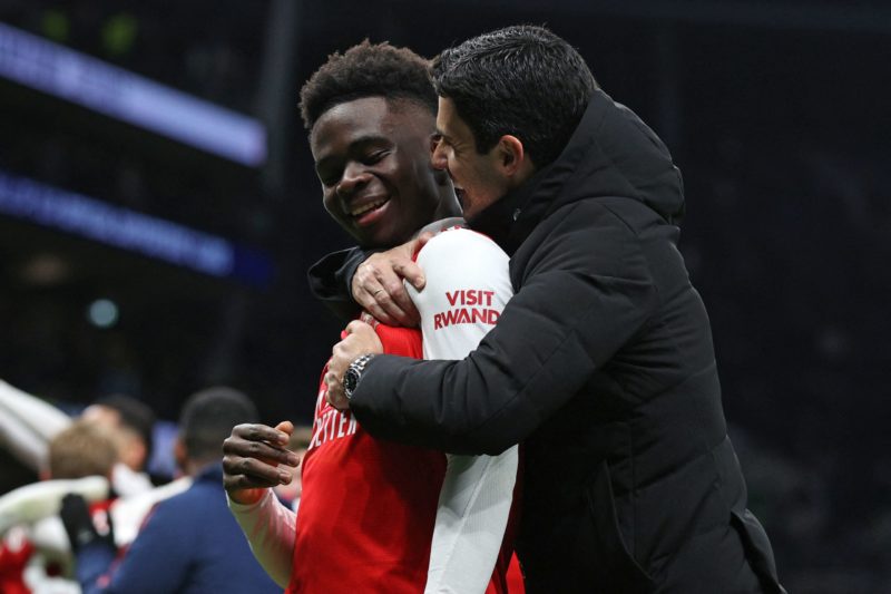 Arsenal's Spanish manager Mikel Arteta (R) celebrates with Arsenal's English midfielder Bukayo Saka on the pitch after the English Premier League f...