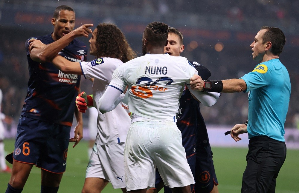 Montpellier's French defender Christopher Jullien (L) and Marseille's Portuguese defender Nuno Tavares (C) argue during the French L1 football matc...