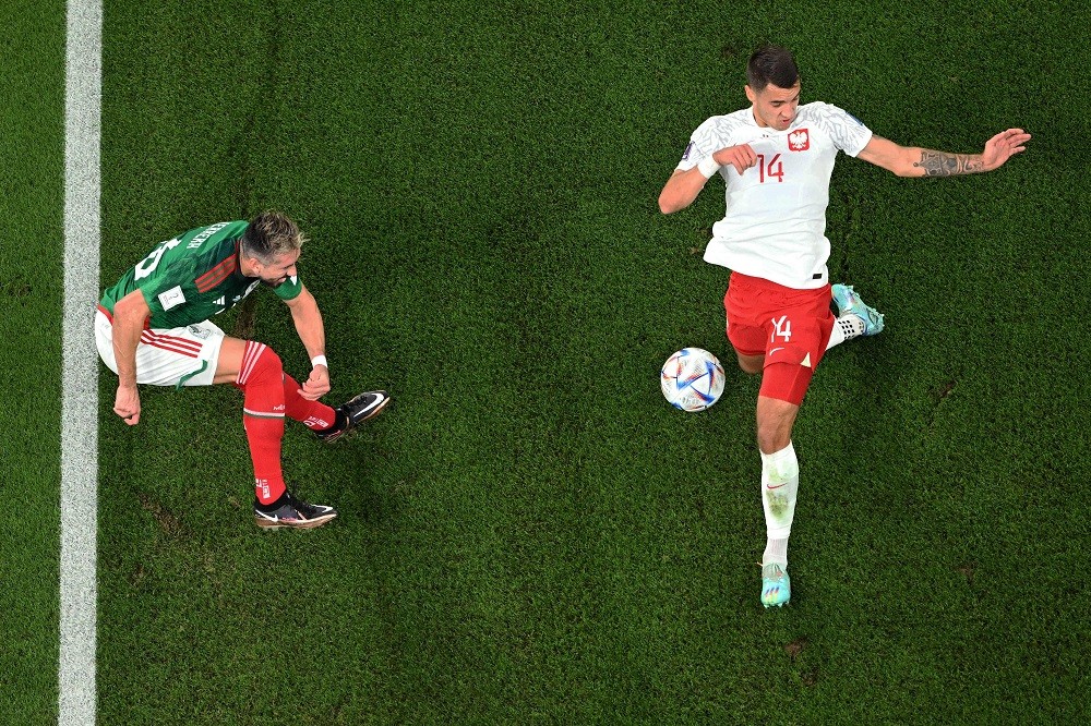 Mexico midfielder Hector Herrera has a shot blocked by Poland defender Jakub Kiwior during the Qatar 2022 World Cup Group C football match between Mexico and Poland at Stadium 974 in Doha on November 22, 2022. (Photo by KIRILL KUDRYAVTSEV/AFP via Getty Images)