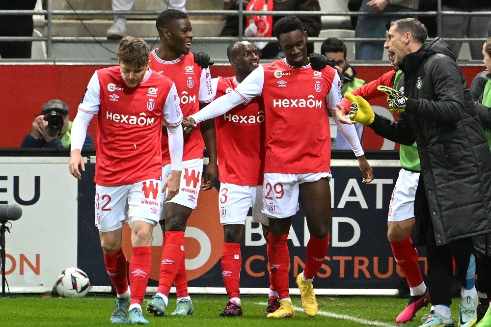 Reims' English forward Folarin Balogun celebrates with teammates after scoring during the French L1 football match between Stade de Reims and FC Lo...
