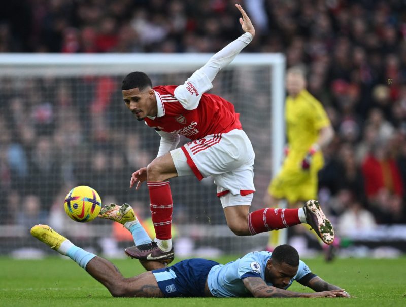 Arsenal's French defender William Saliba (top) fouls Brentford's English striker Ivan Toney during the English Premier League football match betwee...