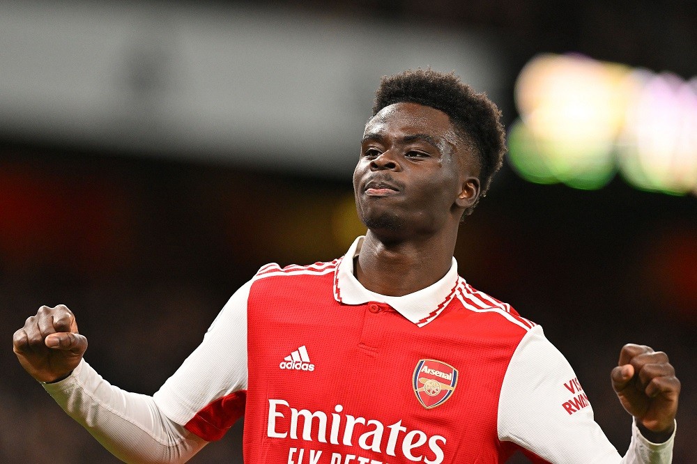 Arsenal's English midfielder Bukayo Saka celebrates scoring the opening goal during the English Premier League football match between Arsenal and E...