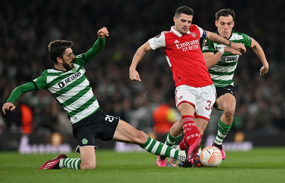 Arsenal's Swiss midfielder Granit Xhaka (C) vies with Sporting Lisbon's Portuguese striker Paulinho (L) and Sporting Lisbon's Uruguayan midfielder ...