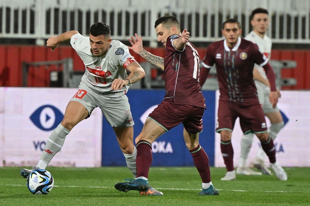 Switzerland's Granit Xhaka (L) fights for the ball with Belarus' Vladimir Khvaschinski during the UEFA Euro 2024 Group I qualification match betwee...