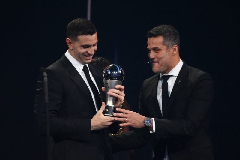 Argentina and Aston Villa goalkeeper Emiliano Martinez (L) receives from Brazilian former football player Julio Cesar the Best FIFA Mens Goalkeeper...