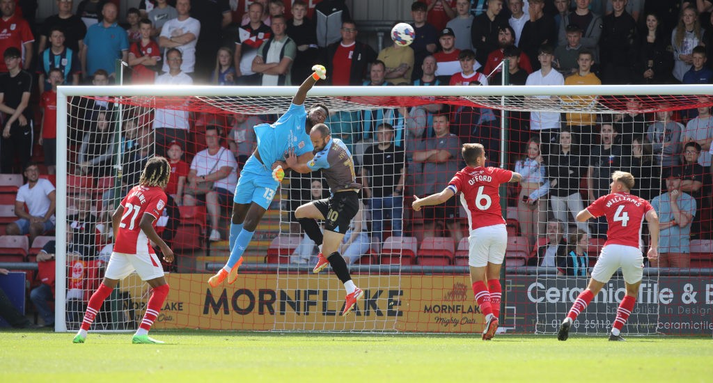 Arsenal loanee shares manager's plan for him this season 4 CREWE, ENGLAND - AUGUST 20: Arthur Okonkwo of Crewe Alexandra attempts to punch the ball under pressure from Danny Hylton of Crewe Alexand during the Sky Bet League Two between Crewe Alexandra and Northampton Town at Mornflake Stadium on August 20, 2022 in Crewe, England. (Photo by Pete Norton/Getty Images)