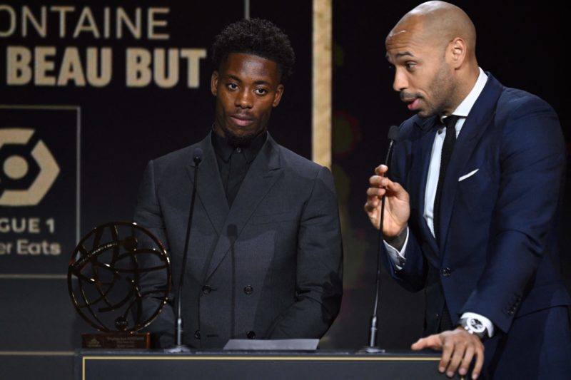 Montpellier's French forward Elye Wahi (L) stands next to French former football player Thierry Henry after receiving the best goal of the year awa...