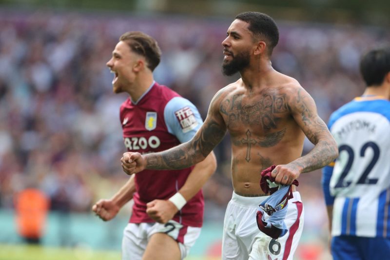 Aston Villa's English defender Matty Cash (L) and Aston Villa's Brazilian midfielder Douglas Luiz (R) celebrate on the final whistle in the English...