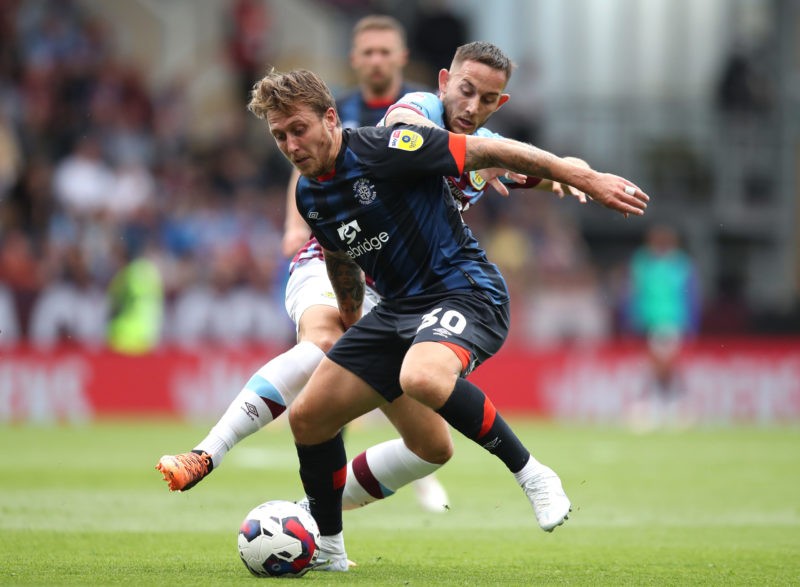 BURNLEY, ENGLAND - AUGUST 06: Luke Freeman of Luton Town keeps ball possession from Josh Brownhill of Burnley FC during the Sky Bet Championship ma...