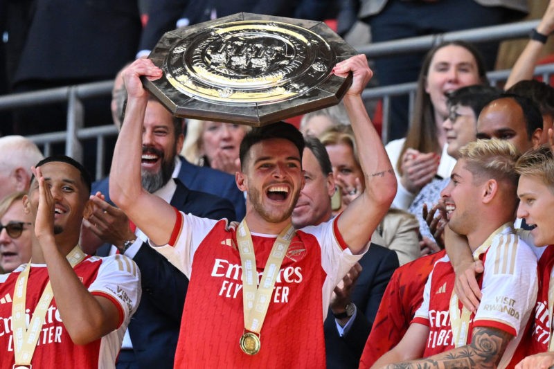 Arsenal's English midfielder Declan Rice (C) lifts the trophy after Arsenal win the shoot-out after the English FA Community Shield football match between Arsenal and Manchester City at Wembley Stadium, in London, August 6, 2023. Arsenal won after a 4-1 penalty shoot-out win, following the 1-1 draw in 90 minutes. (Photo by GLYN KIRK/AFP via Getty Images)