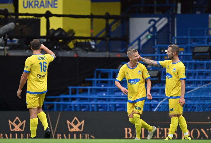 Team Yellow's captain, Ukrainian midfielder Oleksandr Zinchenko (C) reacts with Team Yellow's English midfielder Jack Wilshere (R) as he leaves the pitch after being substituted off during the Game4Ukraine fundraising football match between Oleksandr Zinchenko's team and Andriy Shevchenko's team at Stamford Bridge in London, on August 5, 2023.  (Photo by JUSTIN TALLIS/AFP via Getty Images)