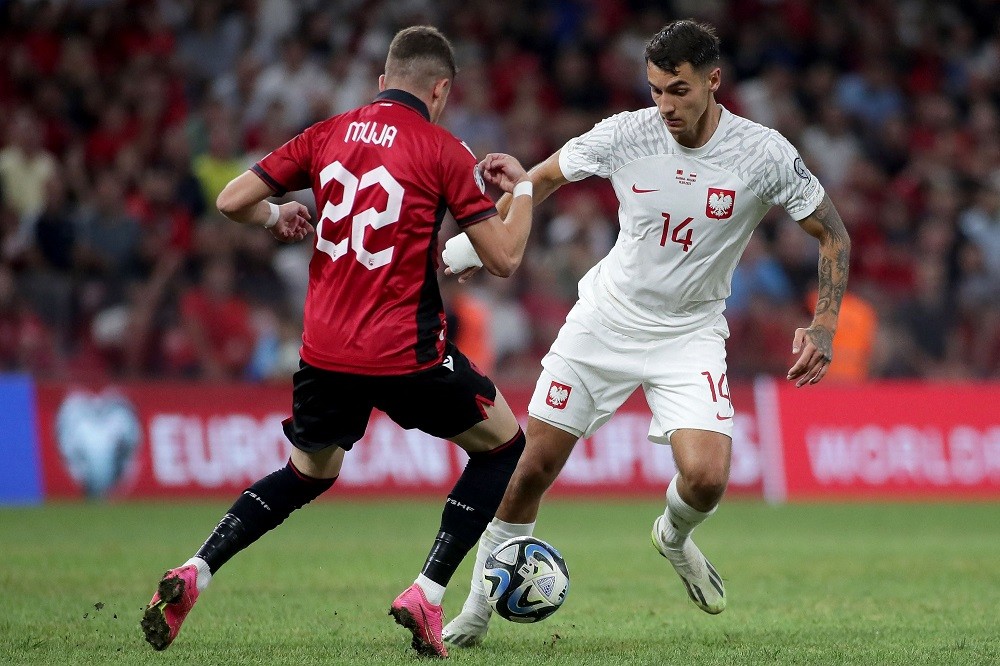 Poland's defender Jakub Kiwior (R) fights for the ball with Albania's forward Arbnor Muja during the UEFA Euro 2024 Group E qualification match bet...