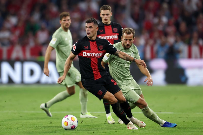 MUNICH, GERMANY - SEPTEMBER 15: Granit Xhaka of Bayer Leverkusen on the ball ahead of Harry Kane of Bayern Munich during the Bundesliga match betwe...