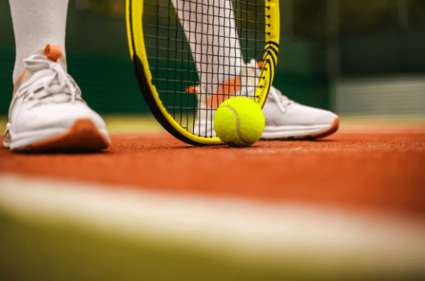 A tennis racket and ball in a field