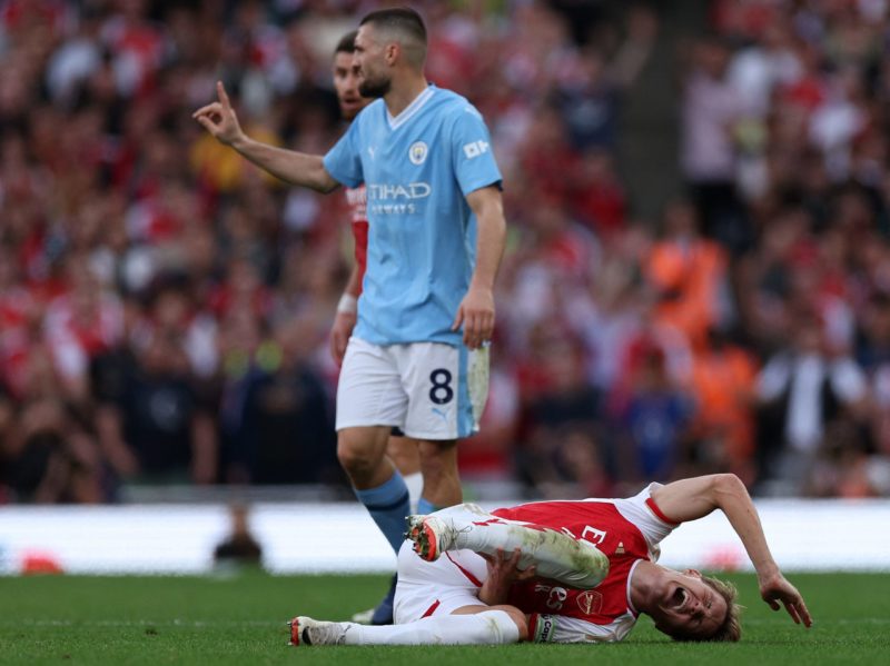 Arsenal's Norwegian midfielder #08 Martin Odegaard (R) reacts after being fouled by Manchester City's Croatian midfielder #08 Mateo Kovacic (C) dur...