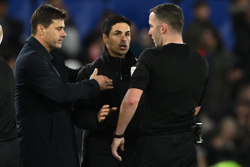 Arsenal's Spanish manager Mikel Arteta (C) talks himself into a yellow card after speaking to English referee Chris Kavanagh (R) as Chelsea's Argen...