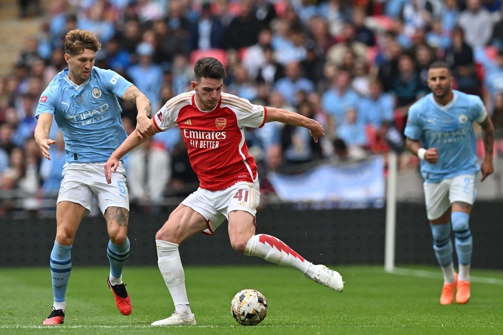 Arsenal's English midfielder Declan Rice (C) vies with Manchester City's English defender John Stones (L) during the English FA Community Shield fo...