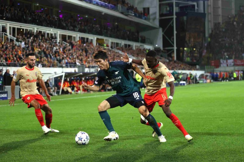 LENS, FRANCE - OCTOBER 03: Takehiro Tomiyasu of Arsenal holds off pressure from Salis Abdul Samed of Lens during the UEFA Champions League match between RC Lens and Arsenal FC at Stade Bollaert-Delelis on October 03, 2023 in Lens, France. (Photo by Alex Pantling/Getty Images)