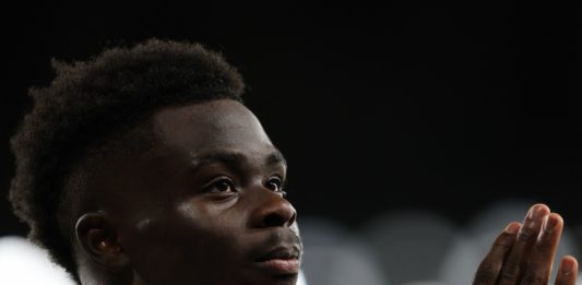 Arsenal's English midfielder #07 Bukayo Saka walks off the pitch after getting injured during the UEFA Champions League Group B football match between Arsenal and Sevilla at the Emirates Stadium in north London on November 8, 2023. (Photo by ADRIAN DENNIS/AFP via Getty Images)