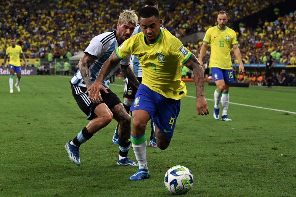 Brazil's forward Gabriel Jesus (front) and Argentina's midfielder Rodrigo De Paul fight for the ball during the 2026 FIFA World Cup South American ...